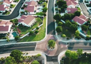 Aerial view of a suburban HOA neighborhood with clean streets, landscaped yards, and organized housing layout.
